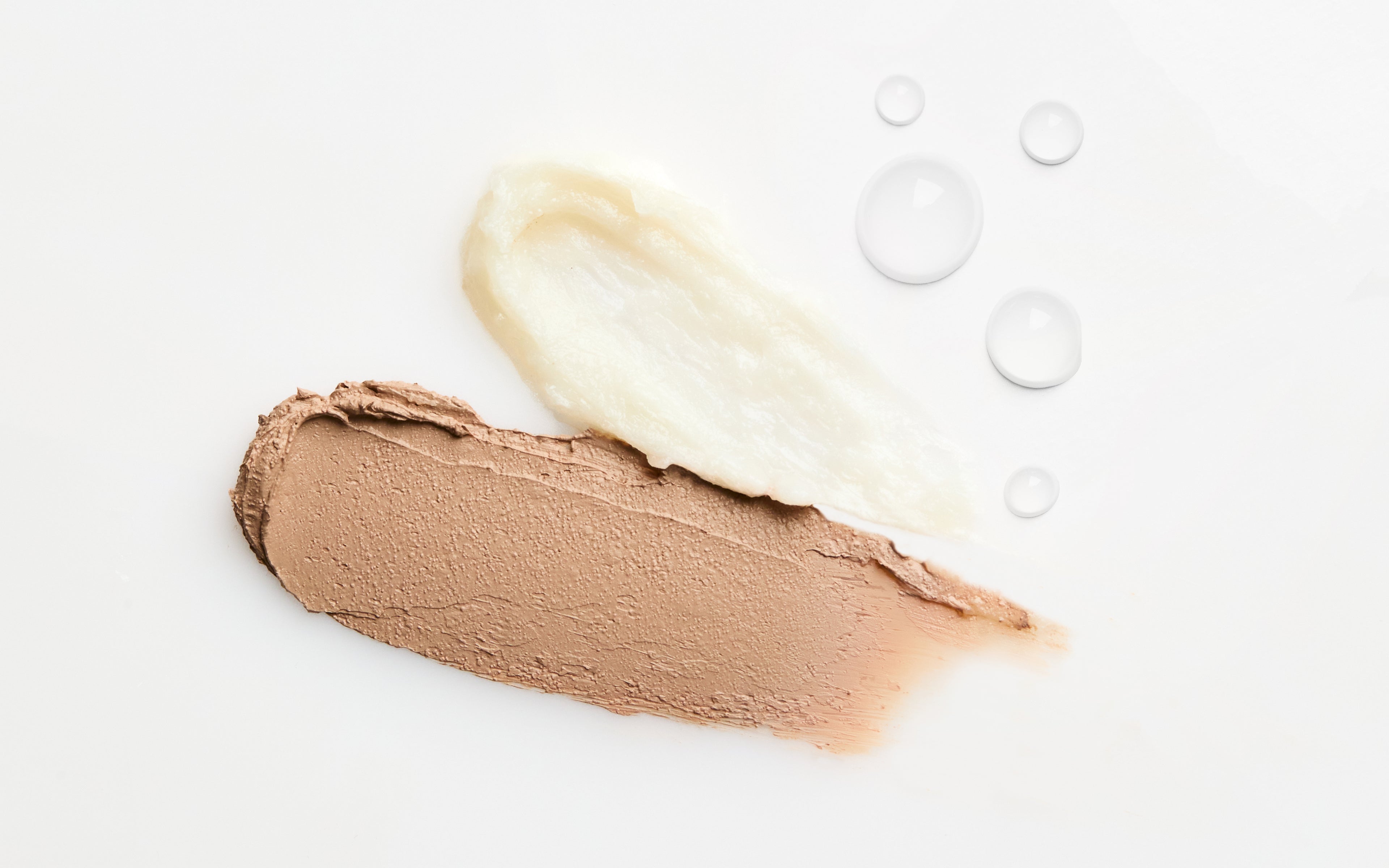 swatches of the coconut cream concealer, sweet mint lip conditioner, and the vitamin boost hydrating face mist against a white background