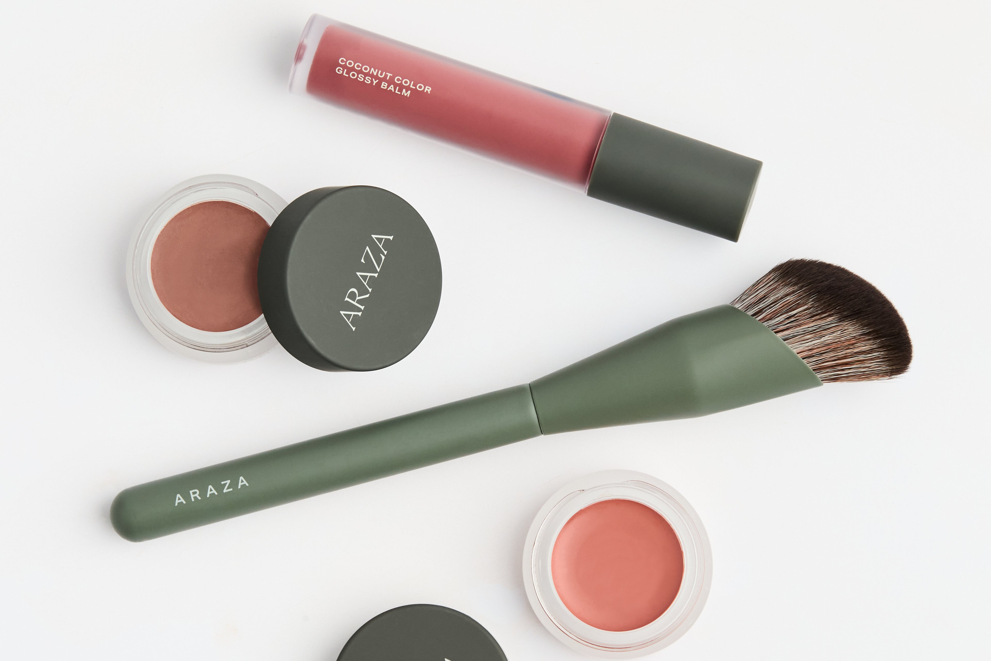 Makeup products including a lip balm, blush, and brush with 'Araza' branding on a white background.